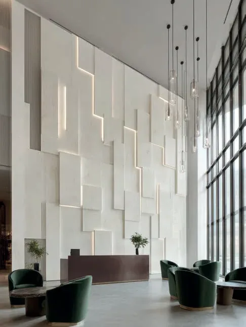 Wysoki hol ze ścianą z bloków Corian® Artista Drift i ladą Artista Mocha