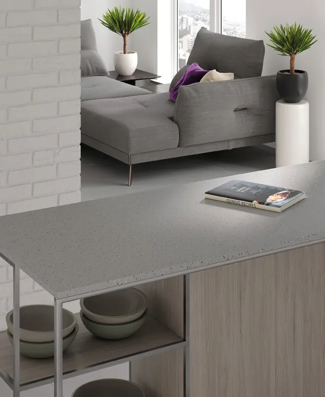 Szary blat solid surface przechodzący w półkę w salonie