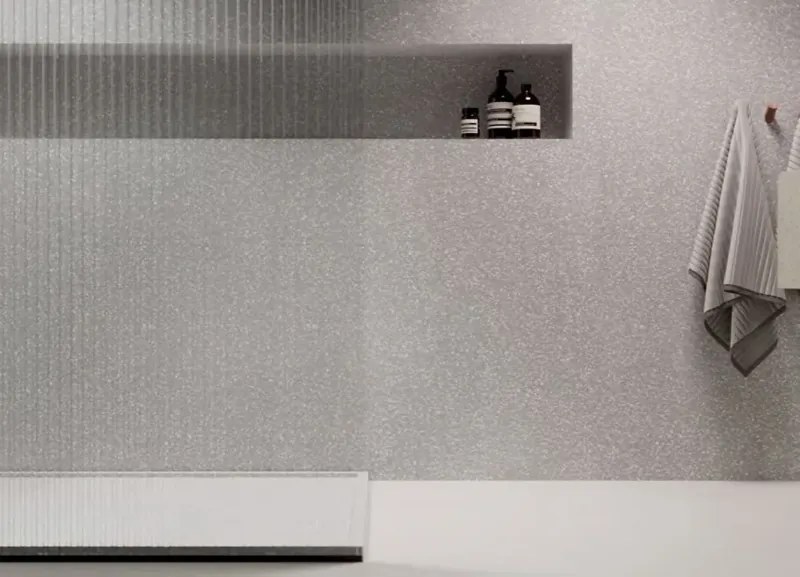 Ściana prysznica bez fug z HIMACS Terrazzo Grigio z wnęką na kosmetyki