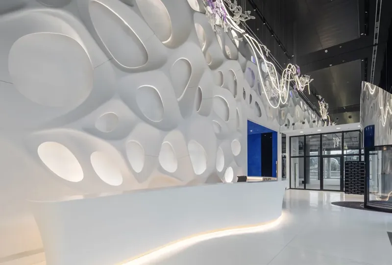 Organiczna ściana Bionic Wall i gięta lada recepcyjna z białego HIMACS w biurowcu w Pradze