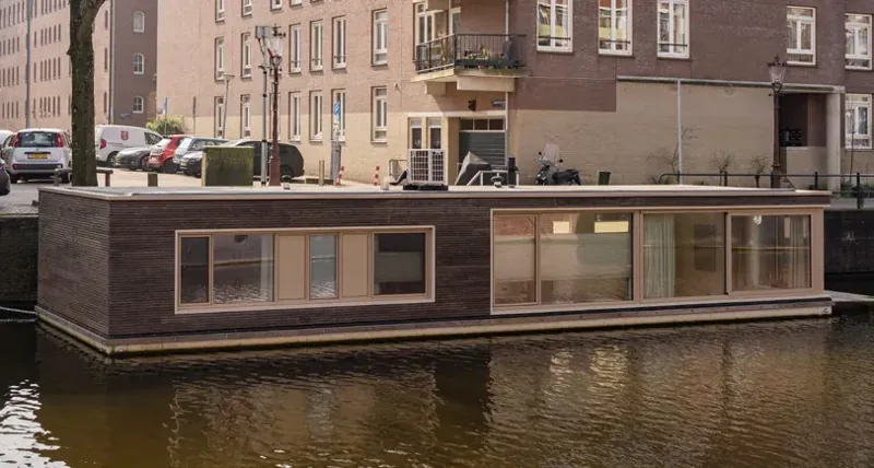 Łódź mieszkalna na kanale w Amsterdamie z oknami w ramach z HIMACS