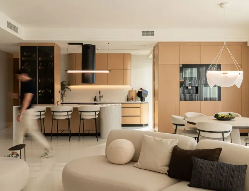 Apartament z wyspą kuchenną i okładziną w jasnym dekorze kamienia