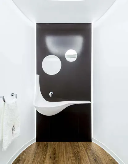 Termoformowana biała umywalka z solid surface na ciemnej ścianie