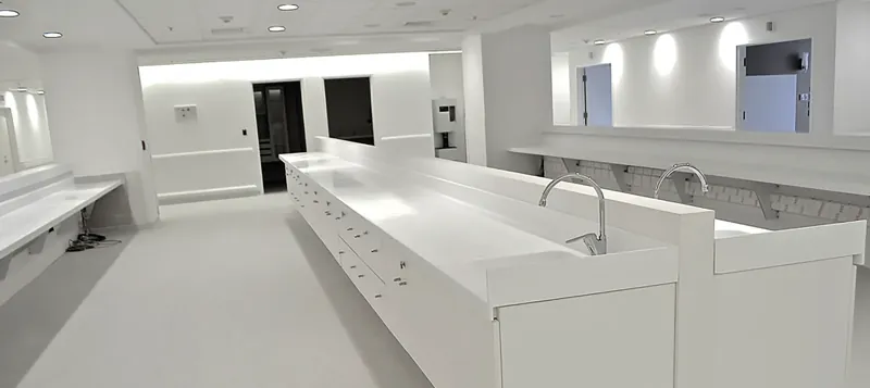 Laboratorium z długim białym blatem solid surface i zlewami